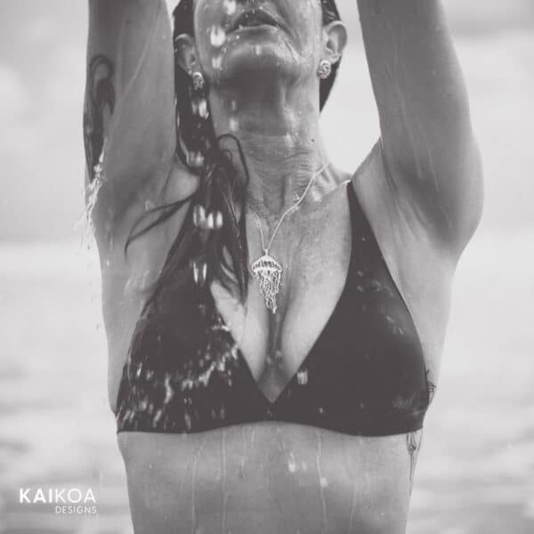 Beautiful women wearing ocean inspired jelly fish sterling pendant at the beach getting wet
